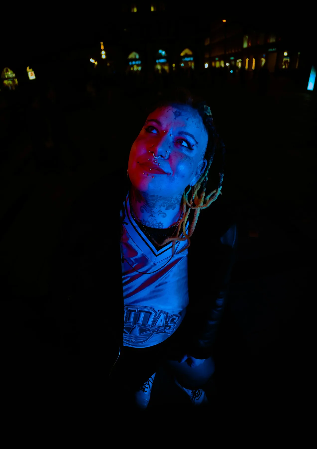 Person lit by red and blue nightlife light.